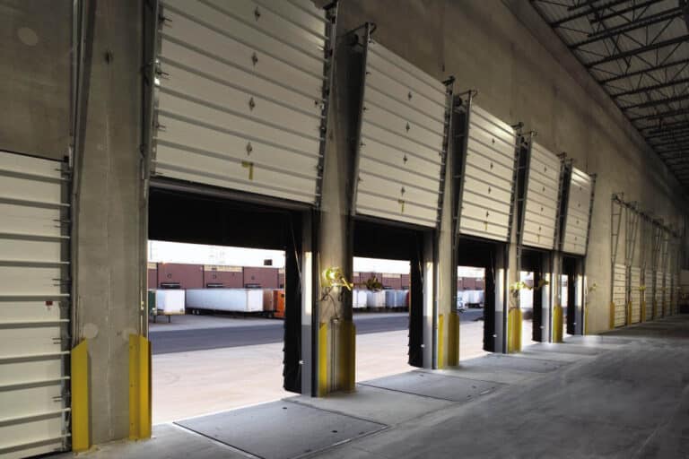 White sectional commercial garage door inside a work facility